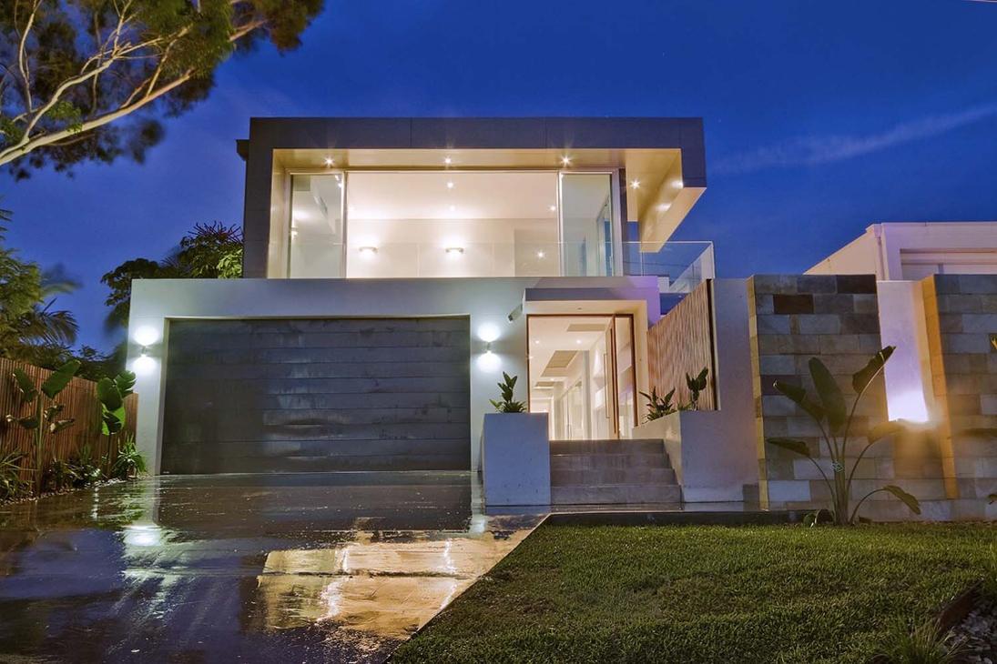 Modern two-story house with illuminated floor-to-ceiling windows and a sleek garage at twilight.